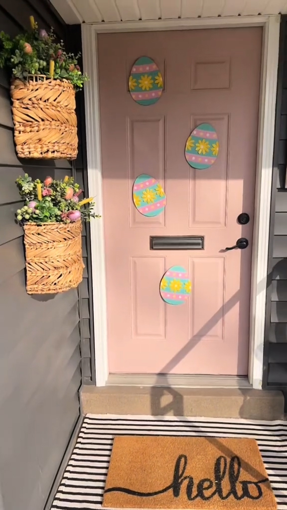 She repurposed yard stakes as door decor and added rattan baskets with colorful flowers