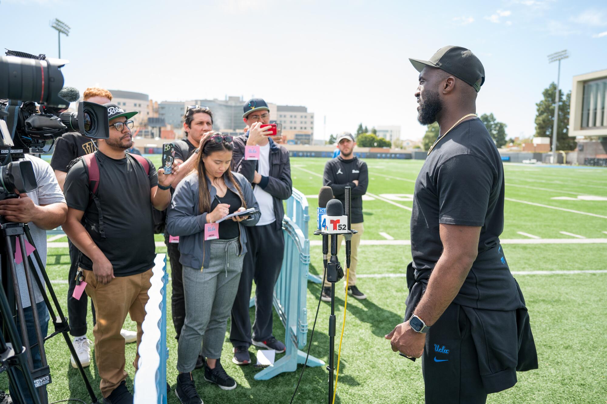 UCLA football coach Deshaun Foster talks with the media after the Bruins' pro day 