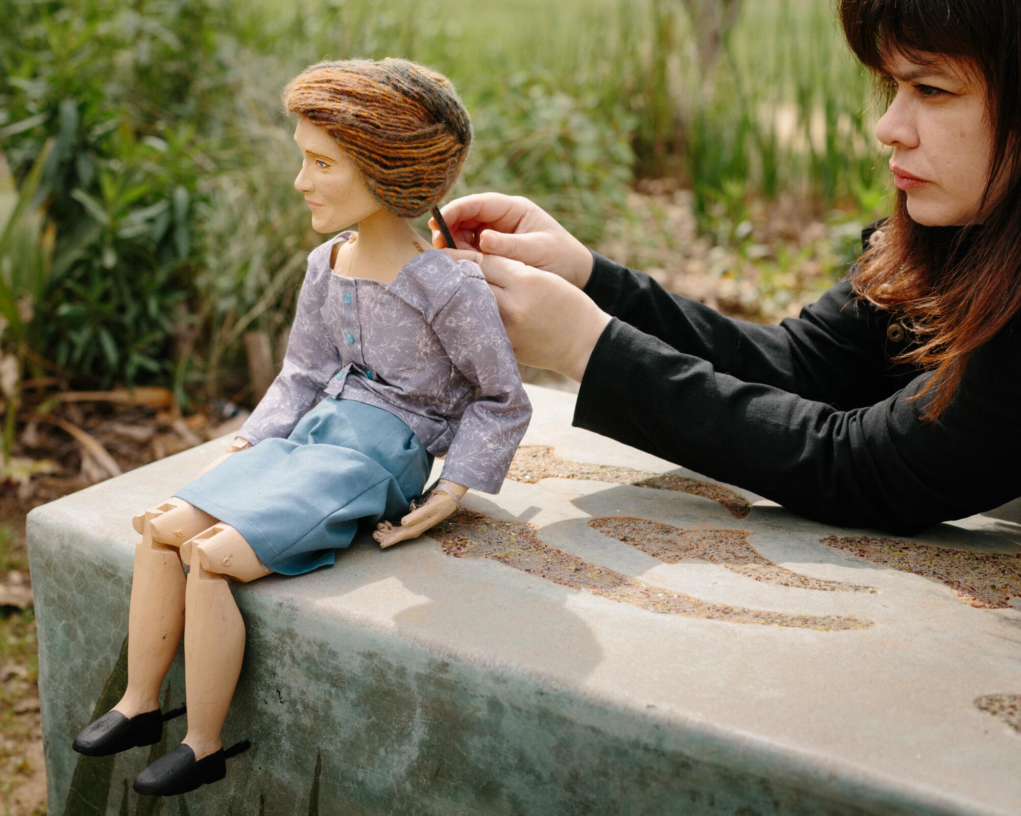 A woman works on her puppet.