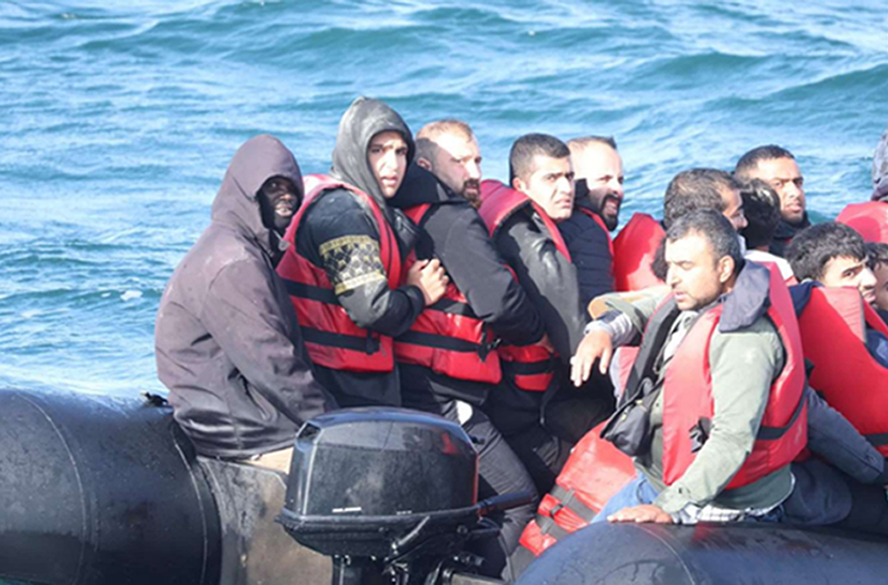 Maker, far left, on the inflatable with other migrants