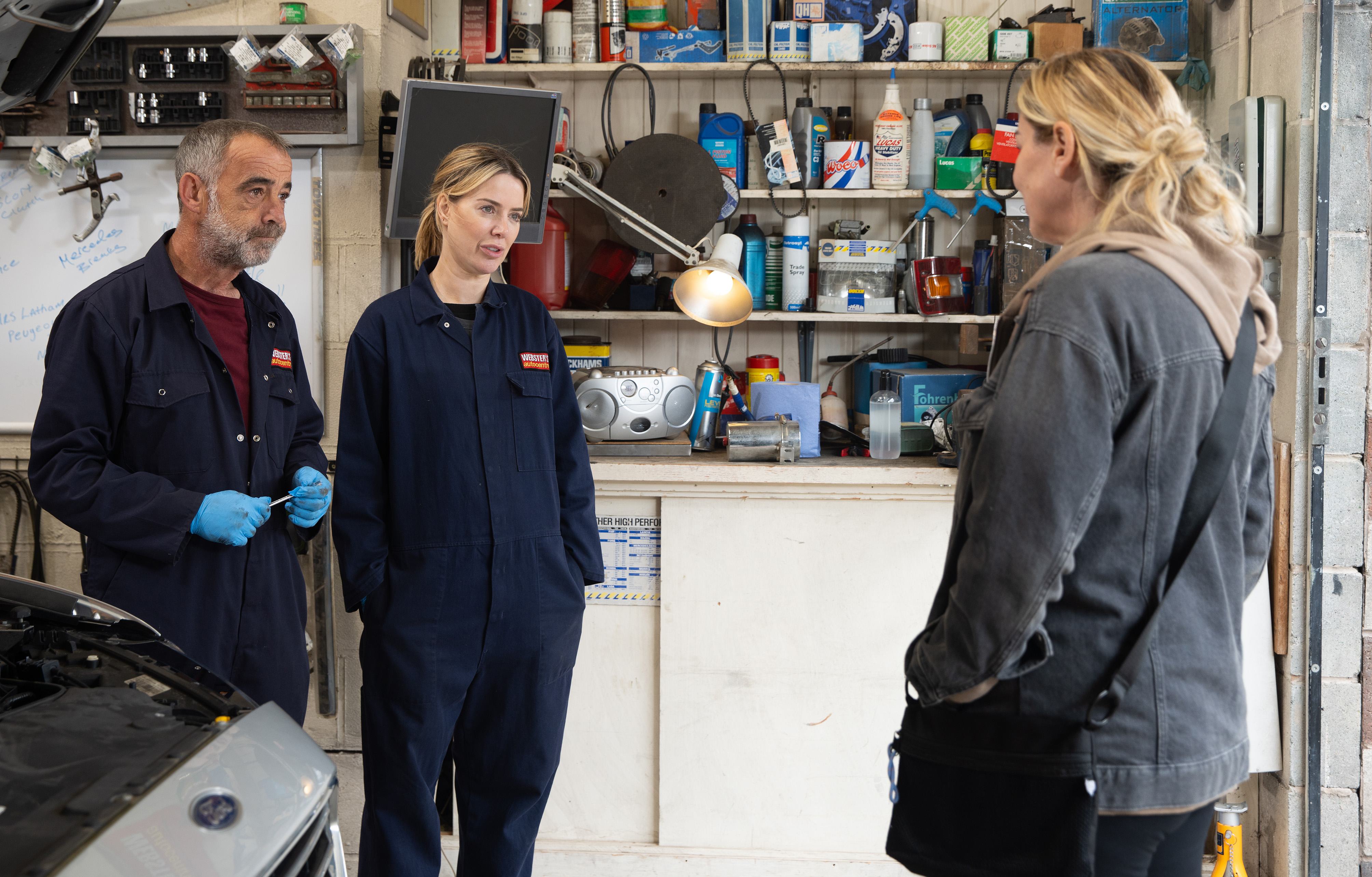 Le Vell as Kevin Webster in his mechanic shop being visited by Clare Sweeney