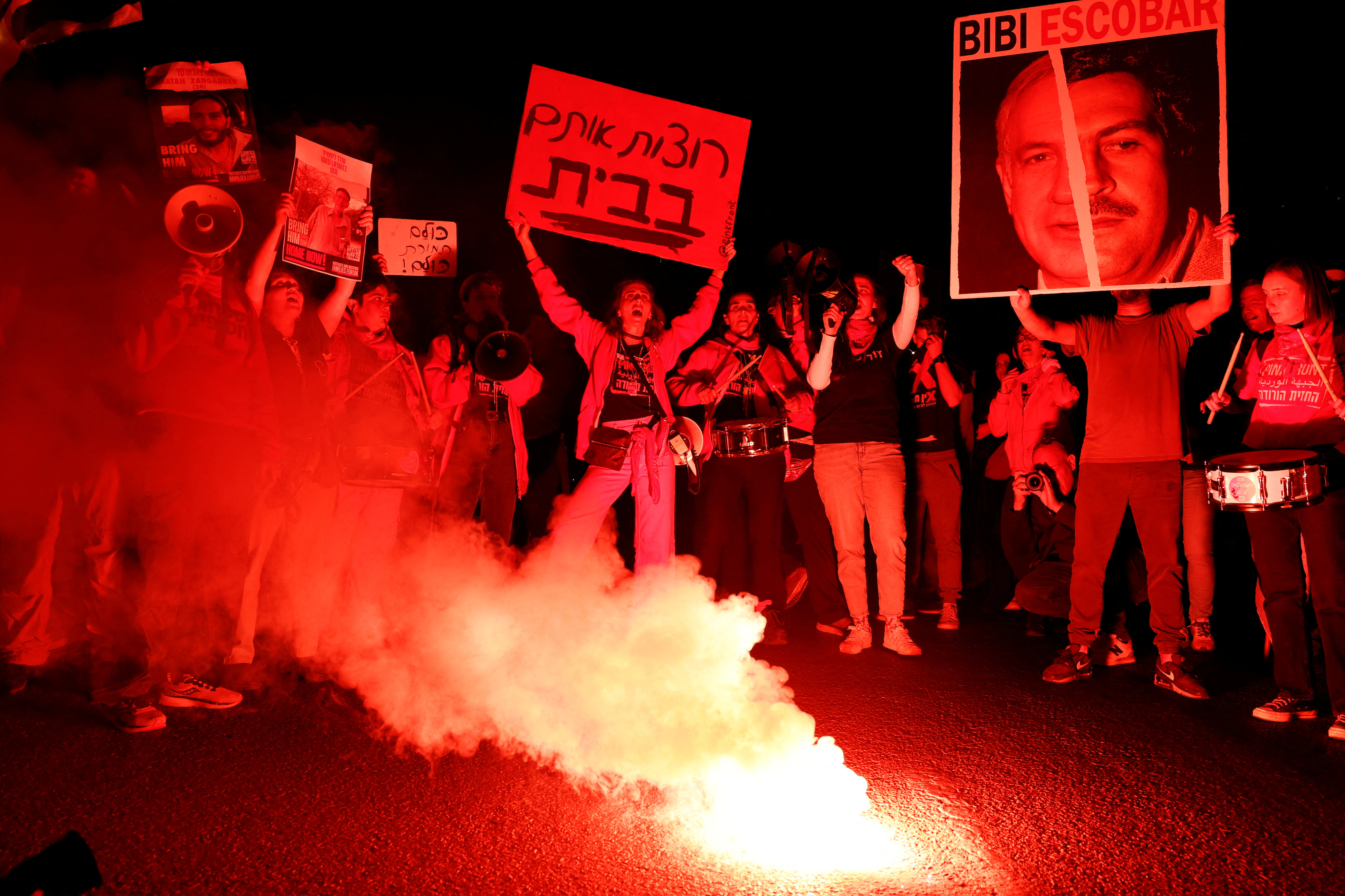 Israelis standing next to a bonfire during a protest against Israeli Prime Minister on March 23