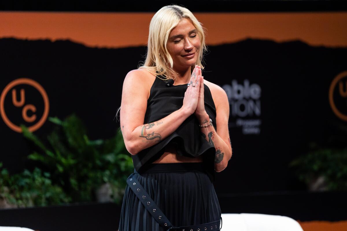 A woman with eyes closed and hands clasped in thanks appears at “A Day of Unreasonable Conversation” at the Getty Center.