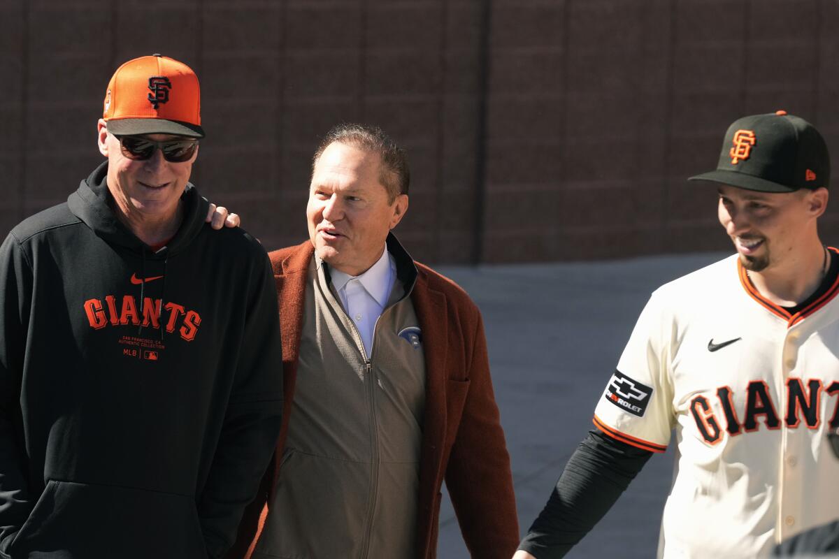 San Francisco Giants manager Bob Melvin, left, smiles as he talks with agent Scott Boras and Blake Snell.