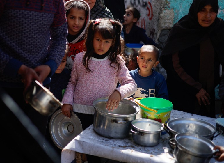 Palestinian children wait to receive food cooked by a charity kitchen amid shortages of food supplies, as the ongoing conflict between Israel and the Palestinian Islamist group Hamas continues, in Rafah, in the southern Gaza Strip, March 5, 2024. REUTERS/Mohammed Salem