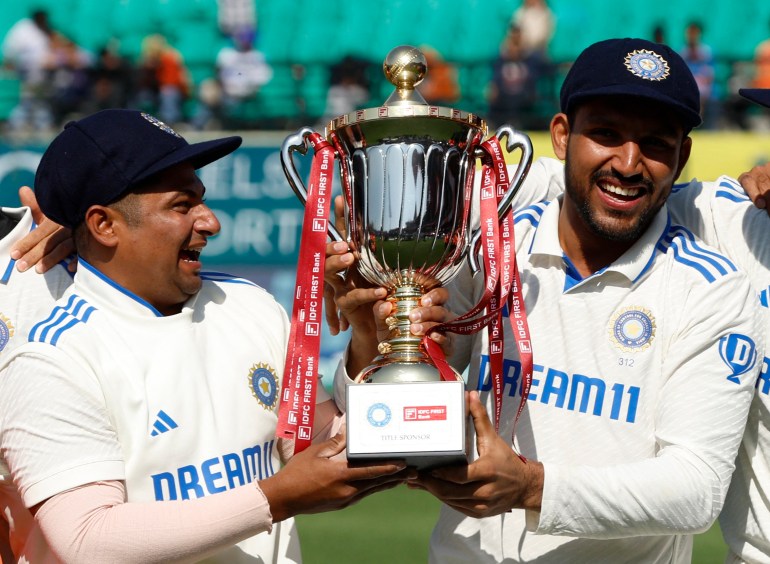 Cricket - Fifth Test - India v England - Himachal Pradesh Cricket Association Stadium, Dharamshala, India - March 9, 2024 India's Sarfaraz Khan and Dhruv Jurel lift the trophy and celebrate after winning the Test series REUTERS/Adnan Abidi