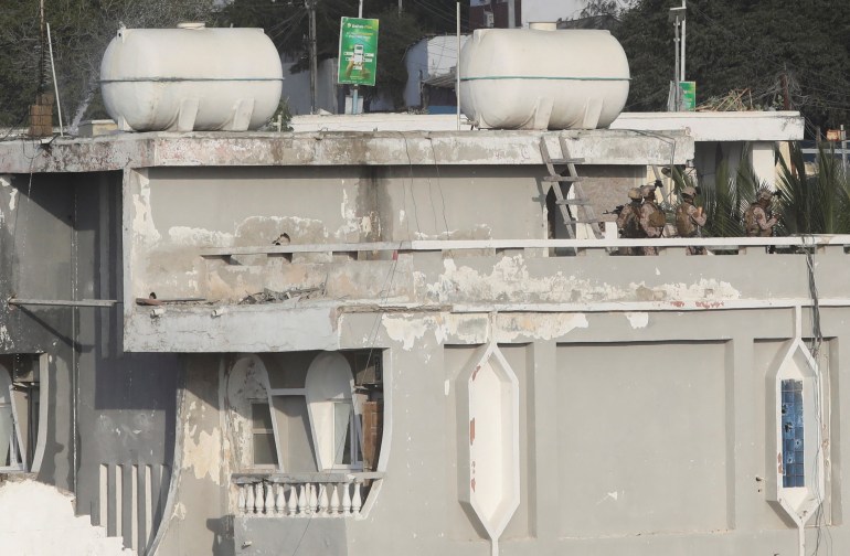 Somali security officers take position on the rooftop at a section of Syl Hotel, the scene of an al Qaeda-linked al Shabaab group's attack in Mogadishu, Somalia