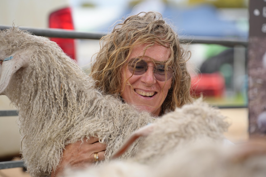 a woman holding a goat 