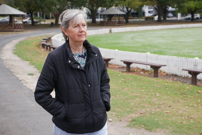 A woman wearing a black jacked walking along a path. 