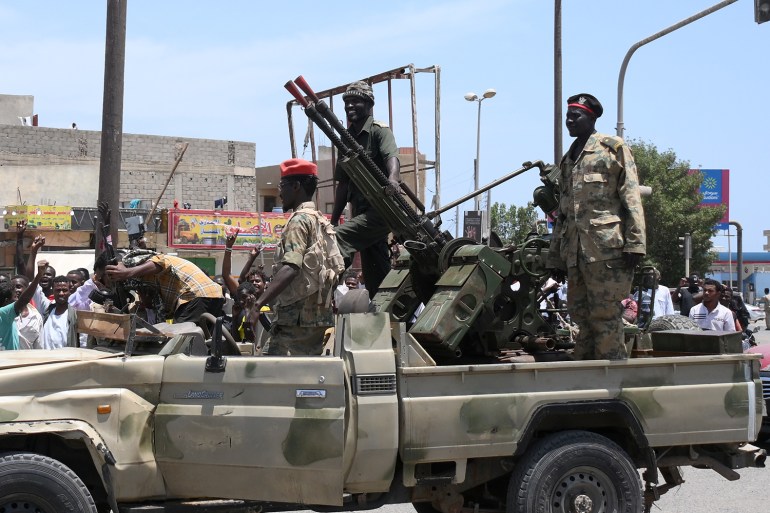 Sudanese greet army soldiers, loyal to army chief Abdel Fattah al-Burhan, in the Red Sea city of Port Sudan