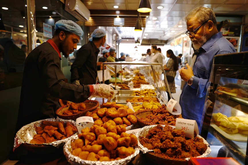 A man looks at food to purchase being sold in a market