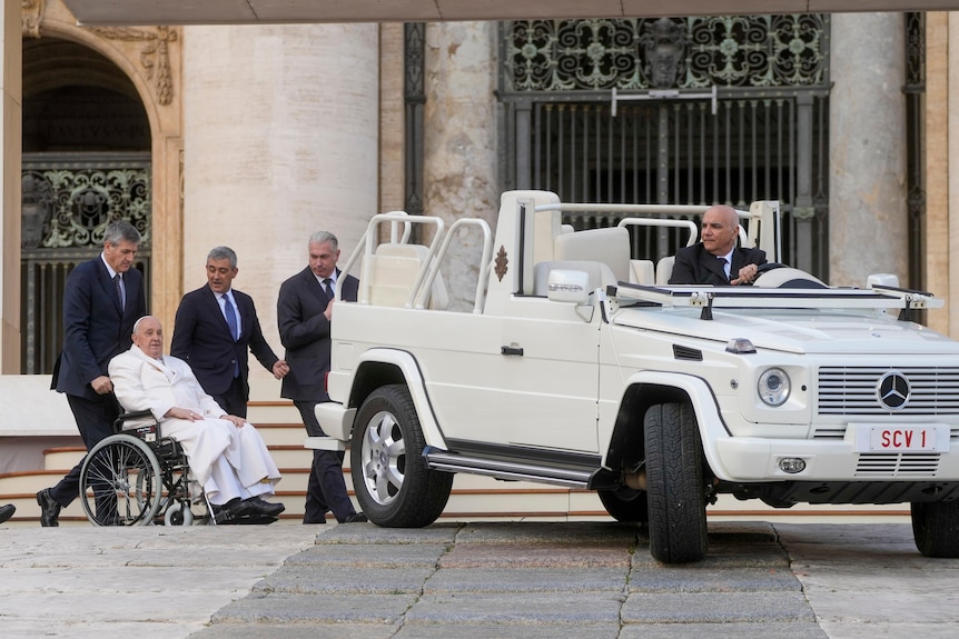 Pope Francis leaves at the end of his weekly general audience in St. Peter's Square he is wheeled near white mercedes