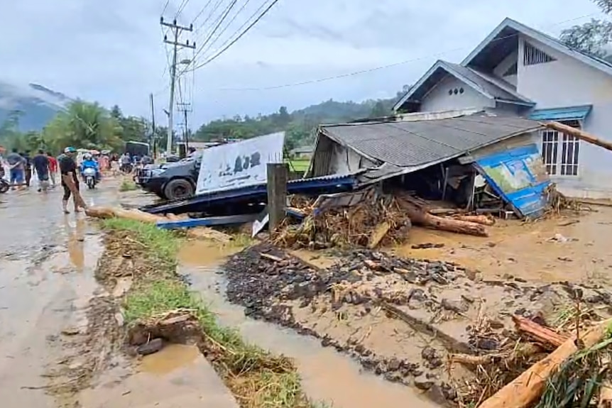 The roof of a home is collapsed after being overcome by mud and debris