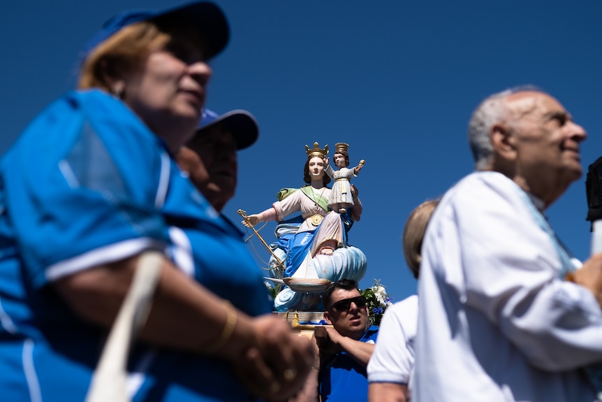 A procession of religious icons while crowds look on