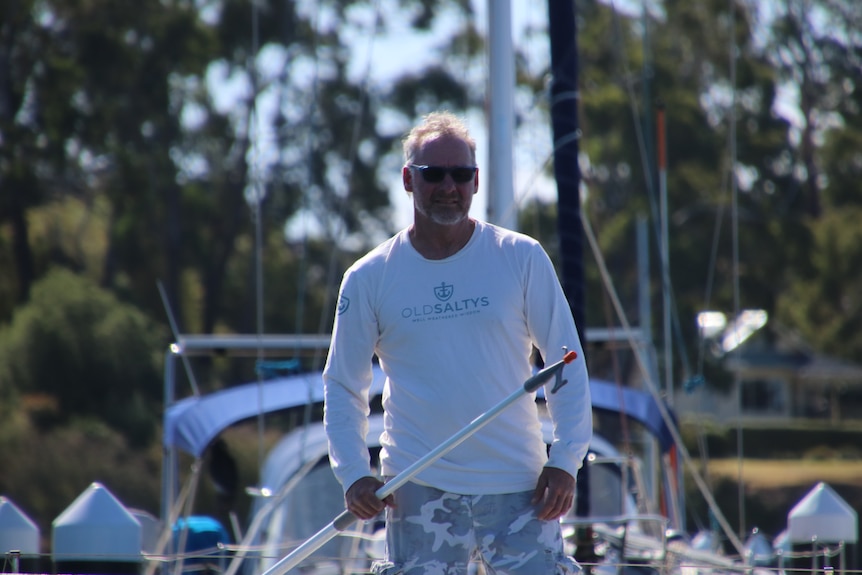 Man leading standing up on a yacht.