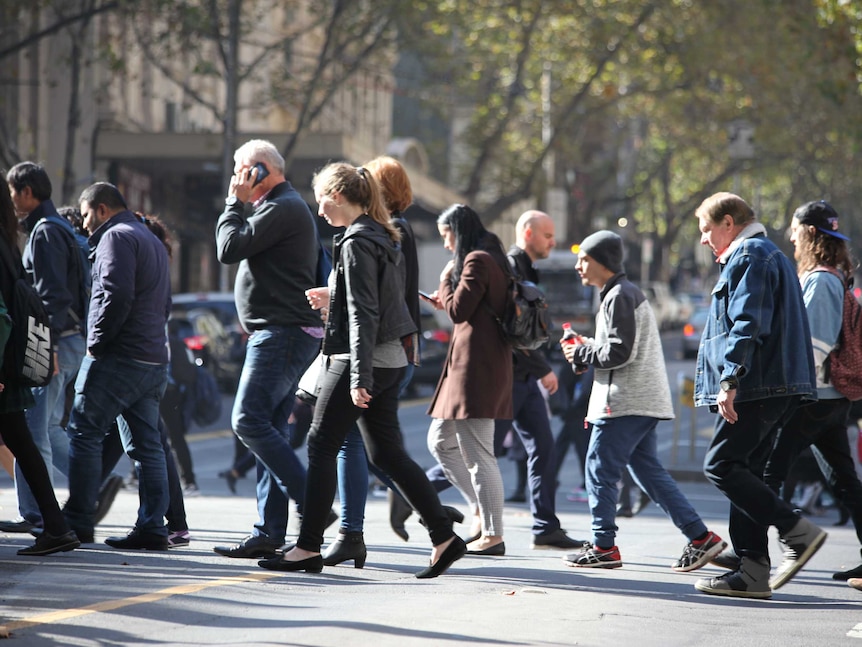 People walk across a street.