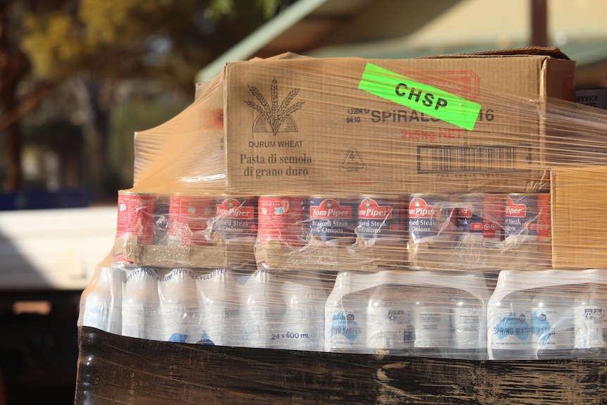 A stack of water, braised steak and pasta waits to be unloaded 