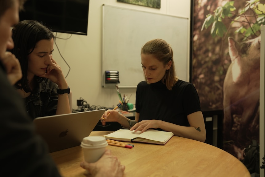 Two women sit at a table.