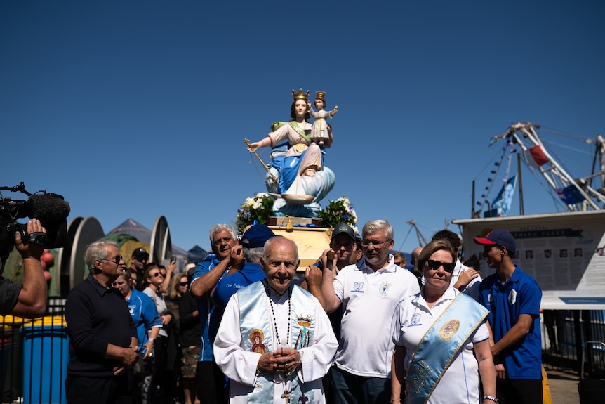 A procession of religious icons while crowds look on