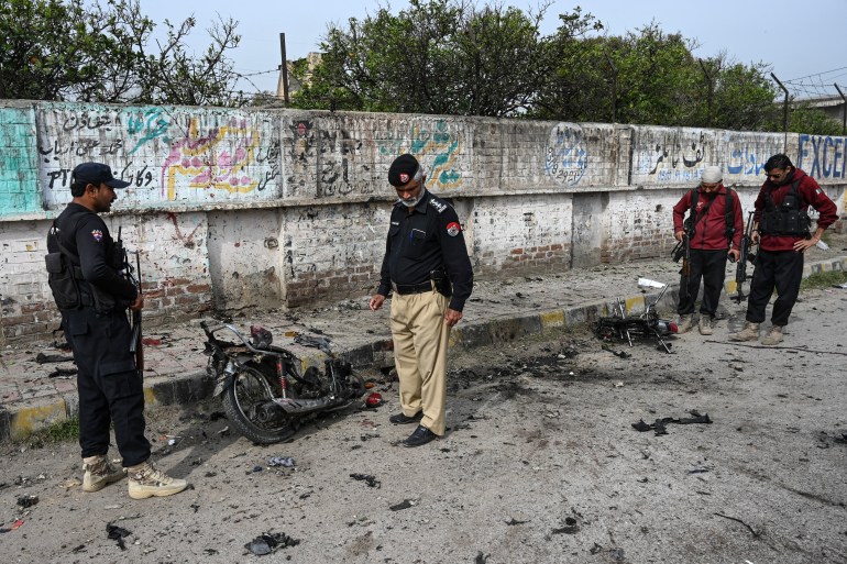 Security personnel examine the site of a blast in Peshawar