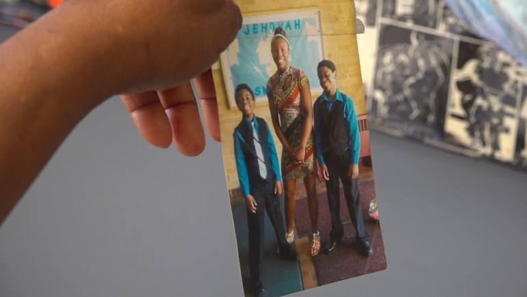 Nadine Young holds up a photo of Ta'Kiya Young with two of her relatives