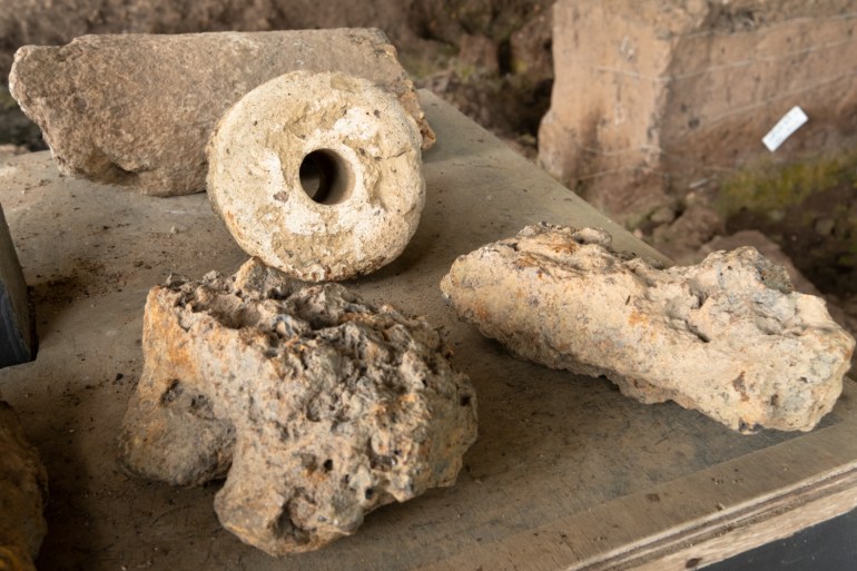 A display of tuyeres, air conduits for iron smelting, found at Sungai Batu Archaeological Complex. They are pale stone tubes with a hole in the middle. 