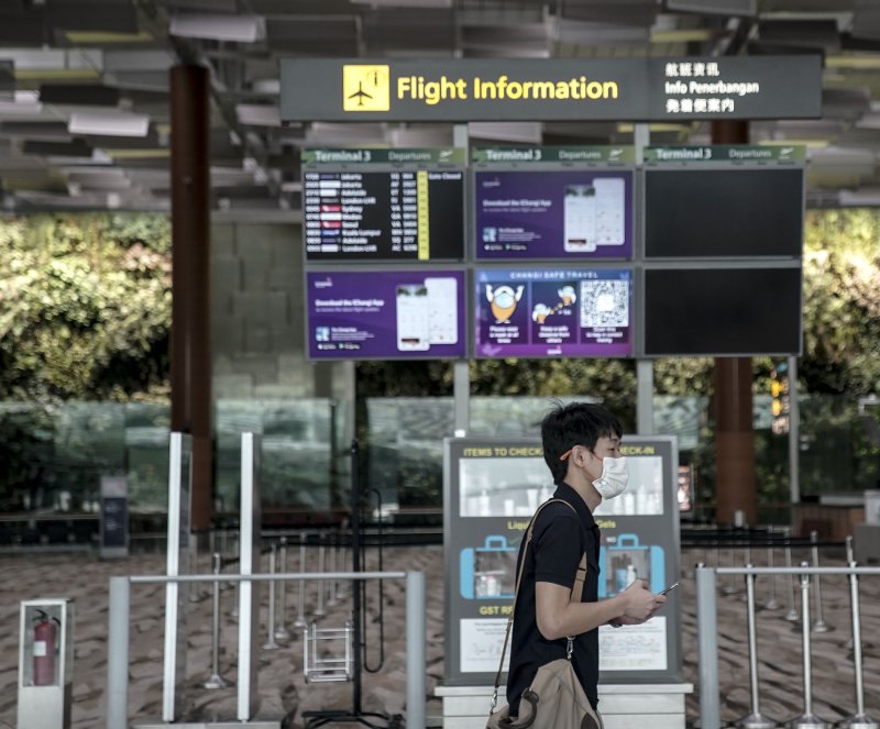 A man walks past a flight information board in the departure hall of the Changi Airport in Singapore in 2020. The airport is known for its over-the-top amenities. File Photo by Wallace Woon/EPA-EFE