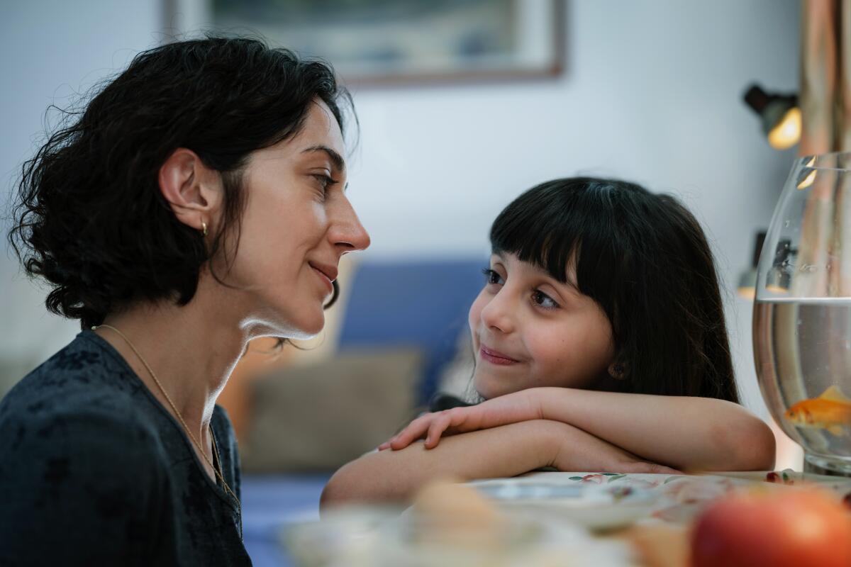 A woman smiles at her daughter.