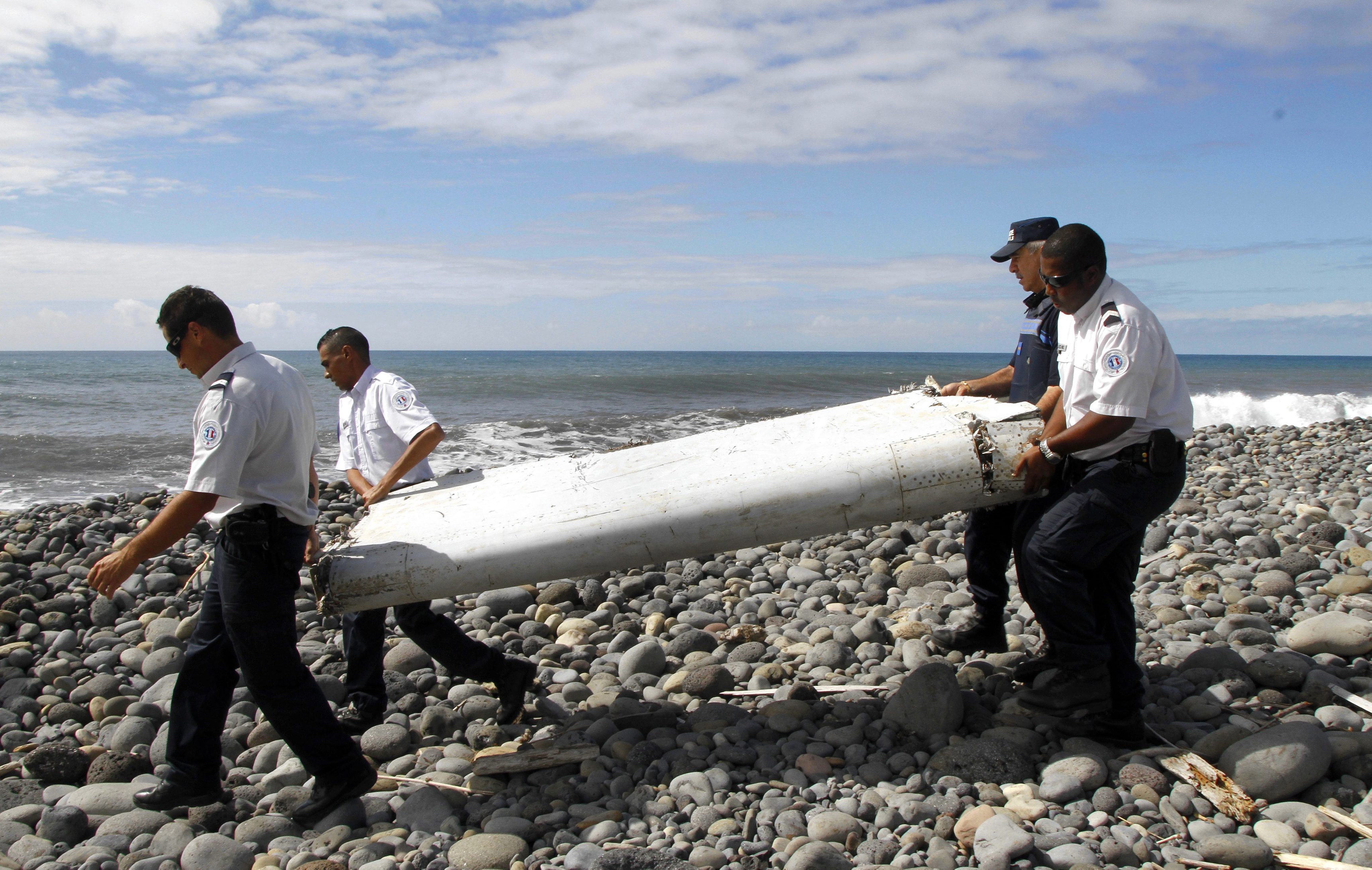 Officers recover debris at Reunion Island in 2015