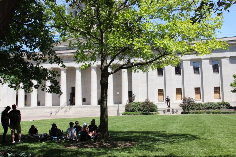 People sit on the grass outside the state house in Columbus, Ohio.