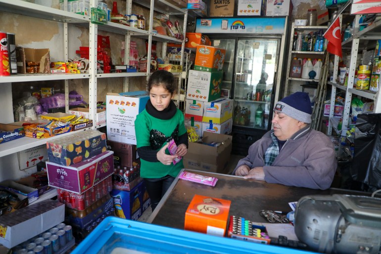 A little girl buys a snack from Qafisheh