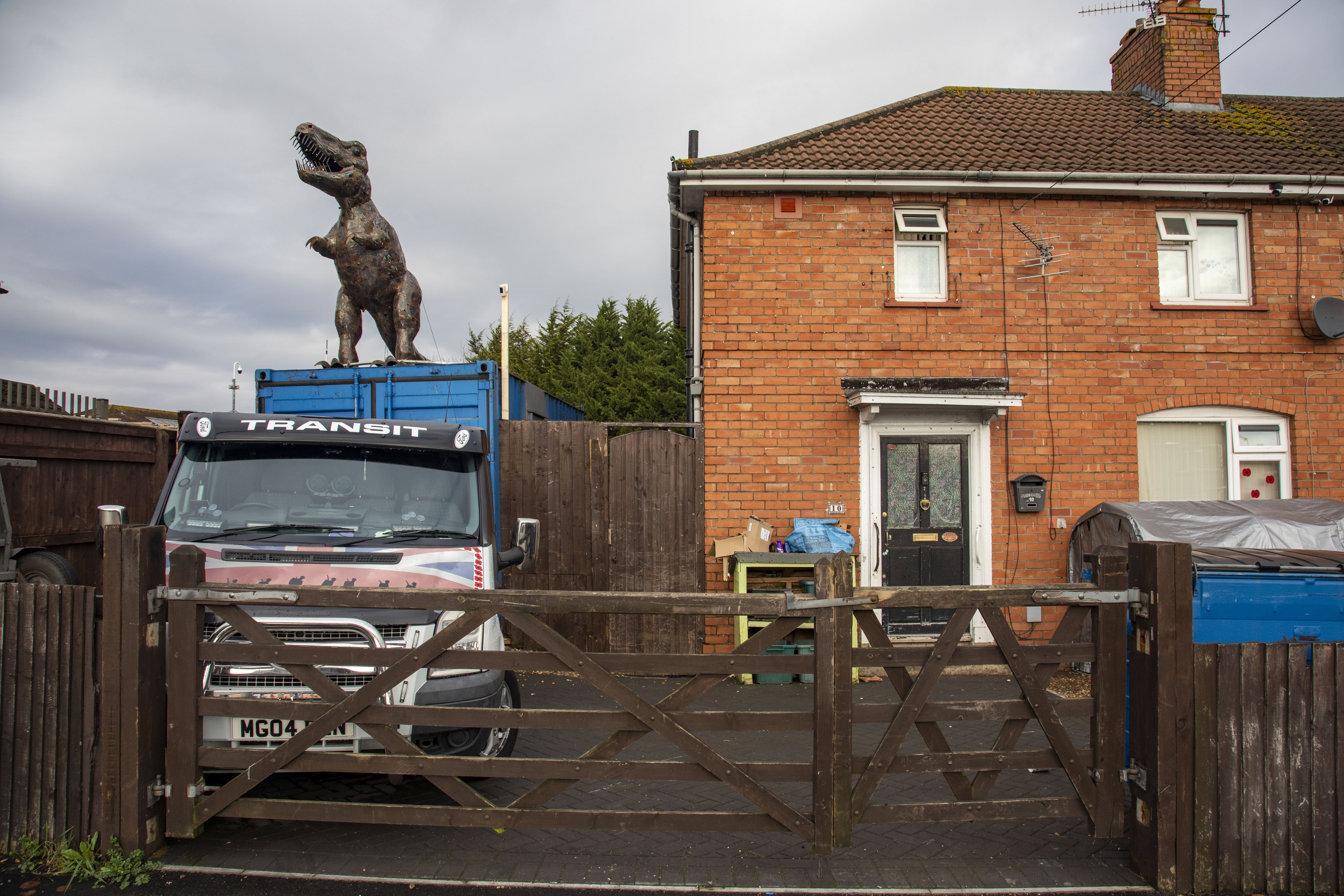Locals have slammed their neighbour for placing a 10ft dinosaur in their driveway