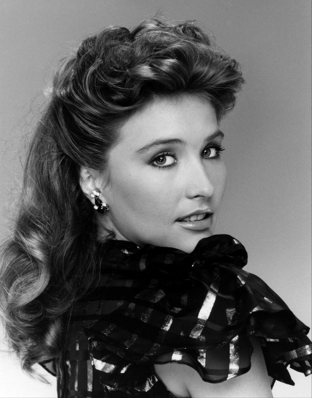 A black-and-white photo of Robyn Bernard looking into the camera over her shoulder. 