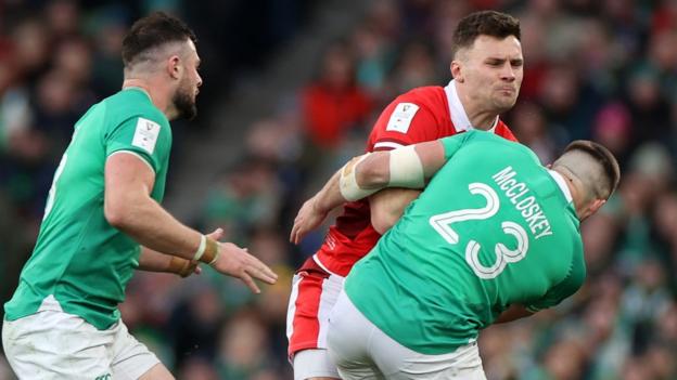 Mason Grady of Wales is tackled by Stuart McCloskey of Ireland