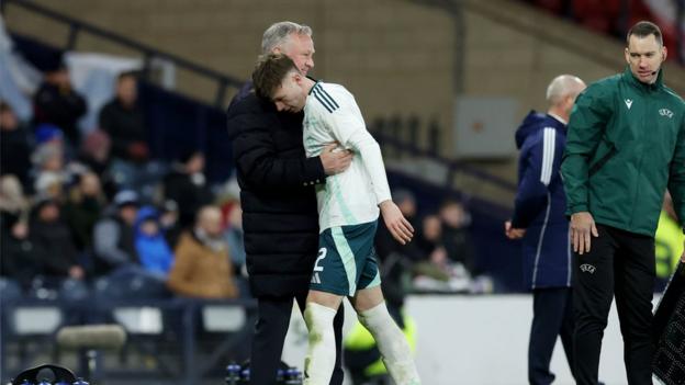 Michael O'Neill embraces Conor Bradley during the win over Scotland