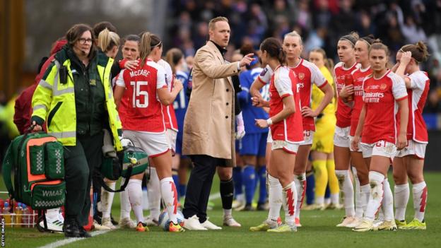 Jonas Eidevall, Manager of Arsenal, talks to the team as Frida Maanum of Arsenal (not pictured) receives medical treatment