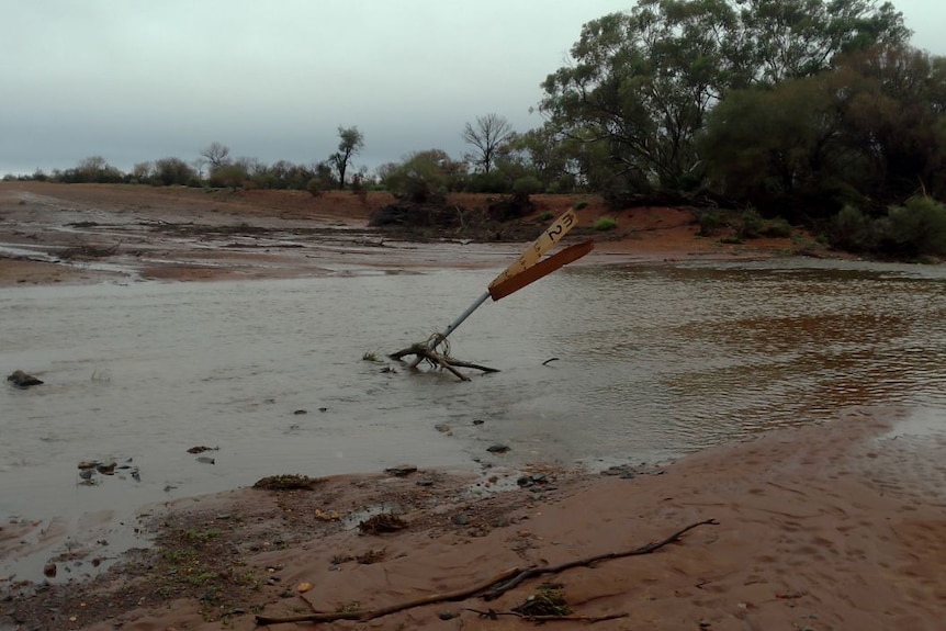 A sign knocked down by flood water 