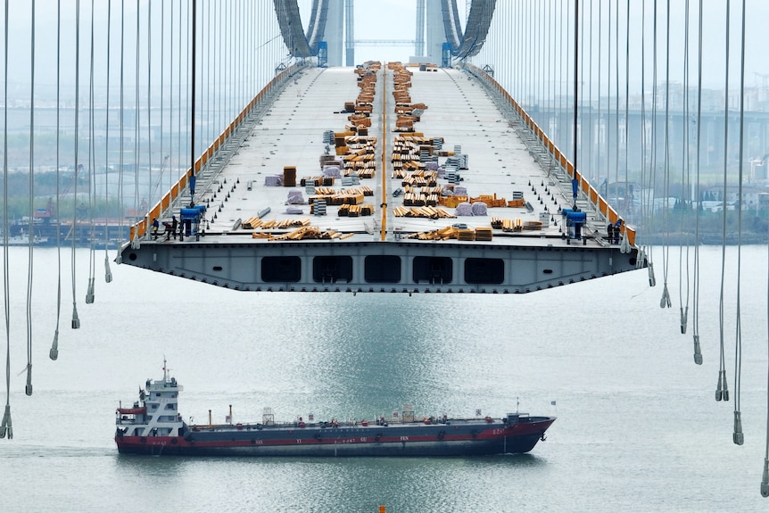  An aerial drone photo shows the construction of a long suspension bridge.