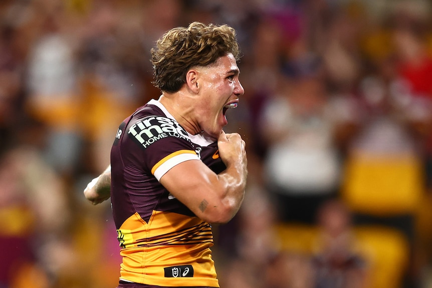 A man celebrates after scoring a try in a rugby league match