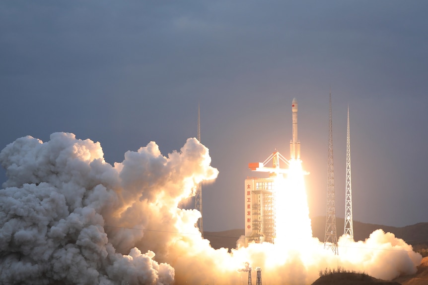 A space rocket blast off leaving a thick grey cloud of exhaust growing from the bright flash of the engine exhaust.