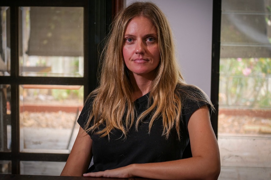 Woman with blonde hair wearing a black shirt.