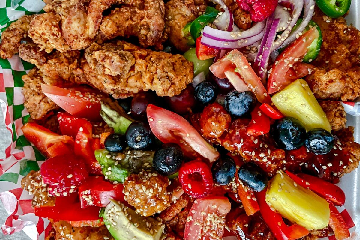 The Director's Cut, a dish of fried chicken scattered with fruits and vegetables, at Gol Tong in Koreatown.