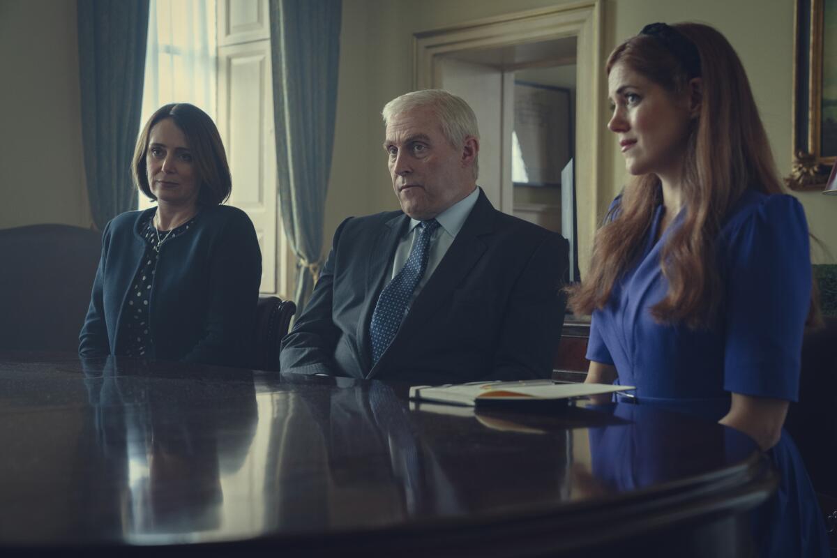 Three people sitting at a desk.