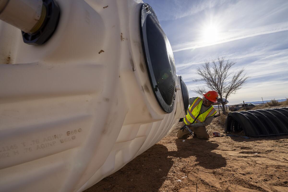 DigDeep employee Nathaniel Sneddy seals a tank lid with silicone.