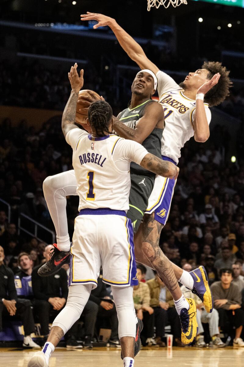 Minnesota forward Jared McDaniels drives to the basket between Lakers center Jaxson Hayes and guard D'Angelo Russell.