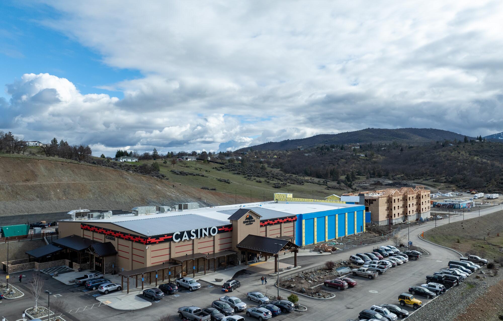 An aerial view of a casino with mountains in the backdrop. 