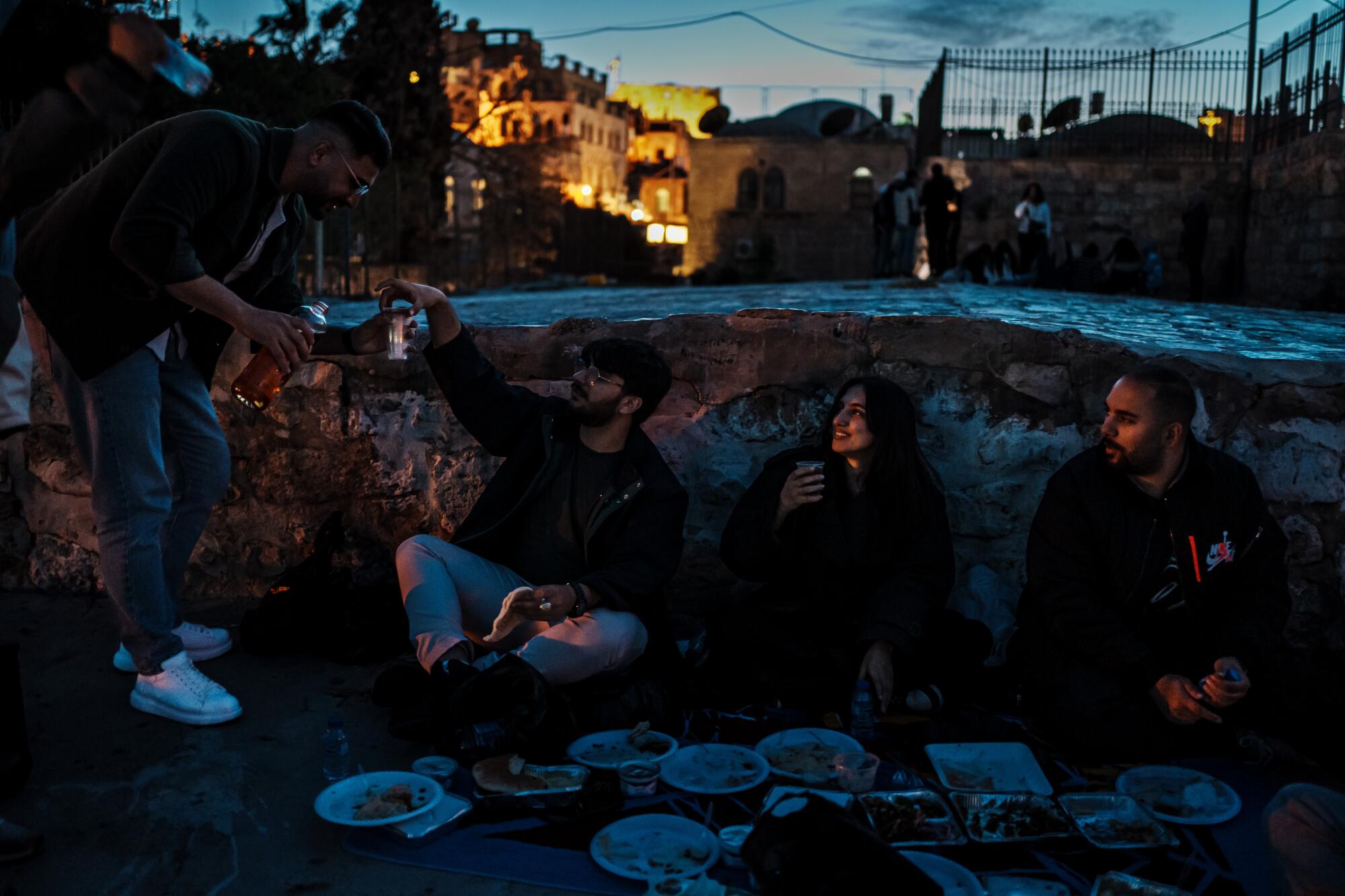 People picnic on a rooftop with views of the Dome of the Rock in Jerusalem's Old City.