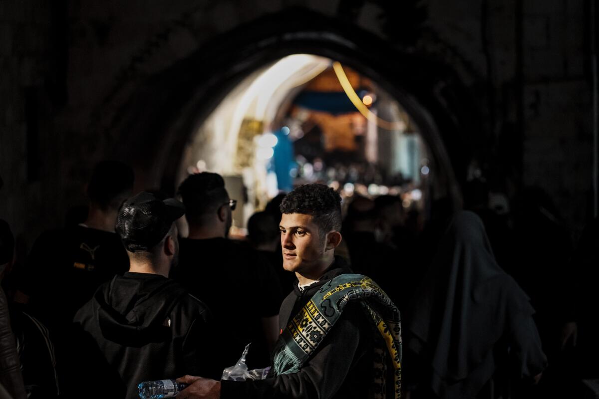 A man hands out water to devout Muslims on their way to Al Aqsa Mosque. 