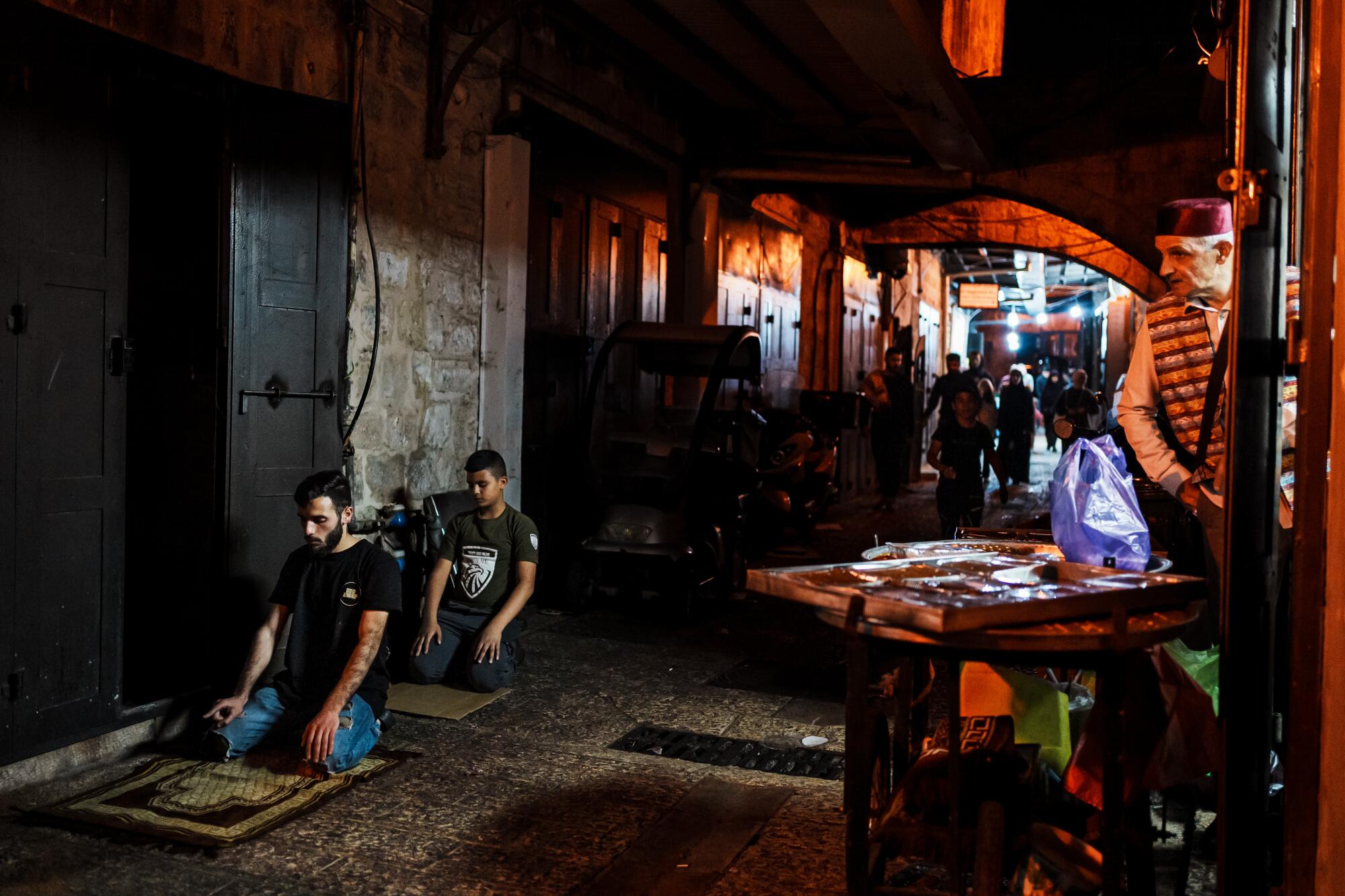 Shop keepers make evening prayers in the old city of Jerusalem.