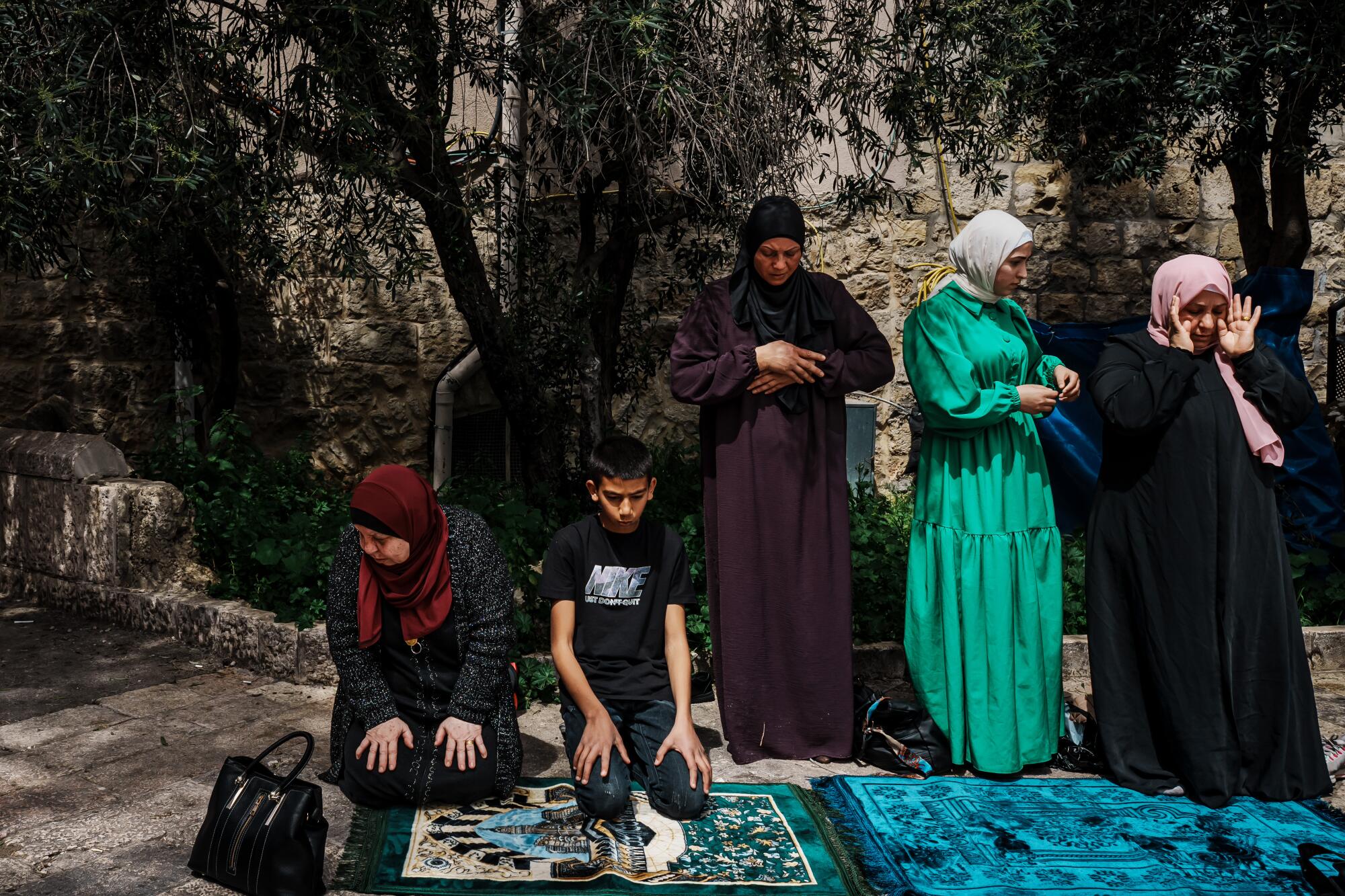 An overflow of worshippers make the Dhuhr afternoon prayers outside the entrance to the Al-Aqsa mosque.